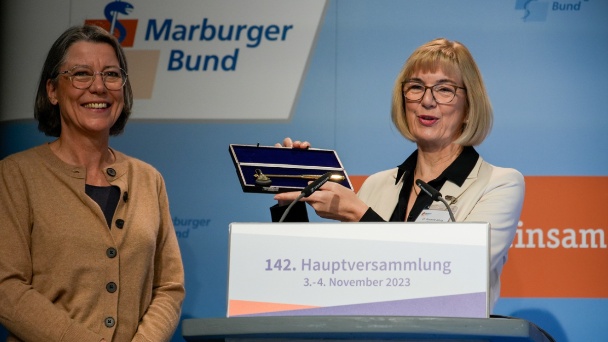 Die 1. Vorsitzende Dr. Susanne Johna überreicht Franziska Schlosser den goldenen Ehrenreflexhammer des Marburger Bundes