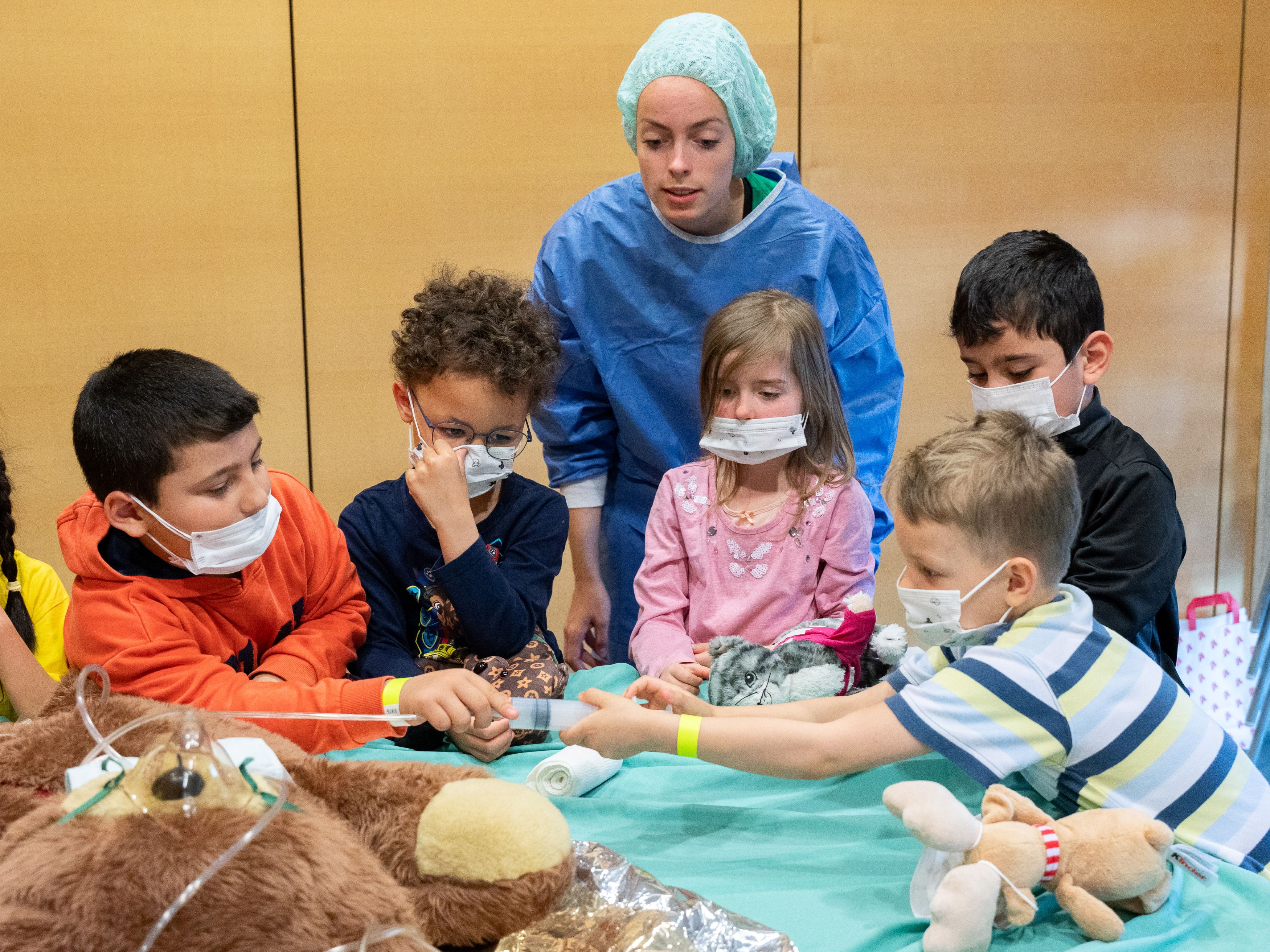 Kinder behandeln unter der Aufsicht einer Medizinstudierenden spielerisch ihre Kuscheltiere. Bild: @UKD/Michael Kretzschmar
