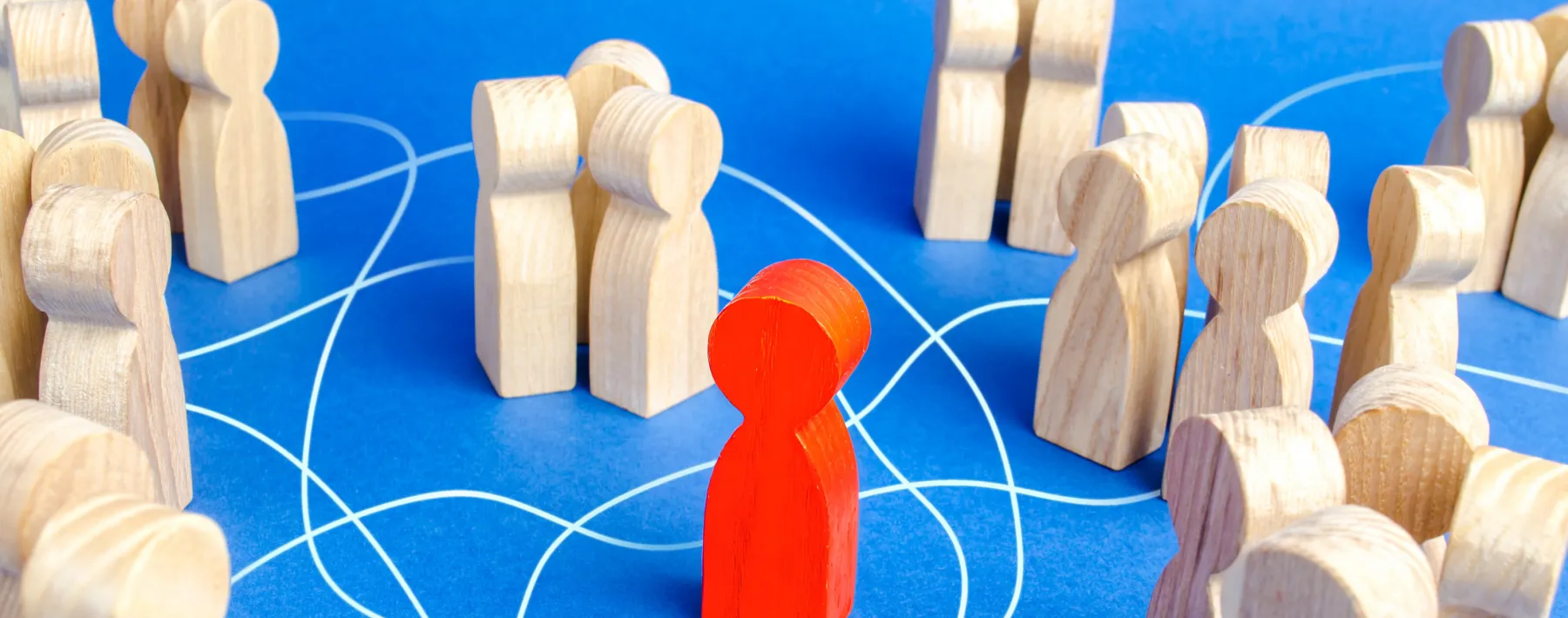 symbolische Opferposition: Holzfiguren, in der Mitte eine rot gefärbte